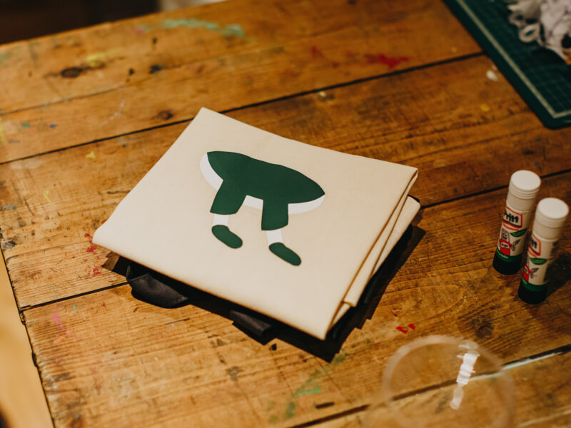 A small pile of screen prints on a wooden table